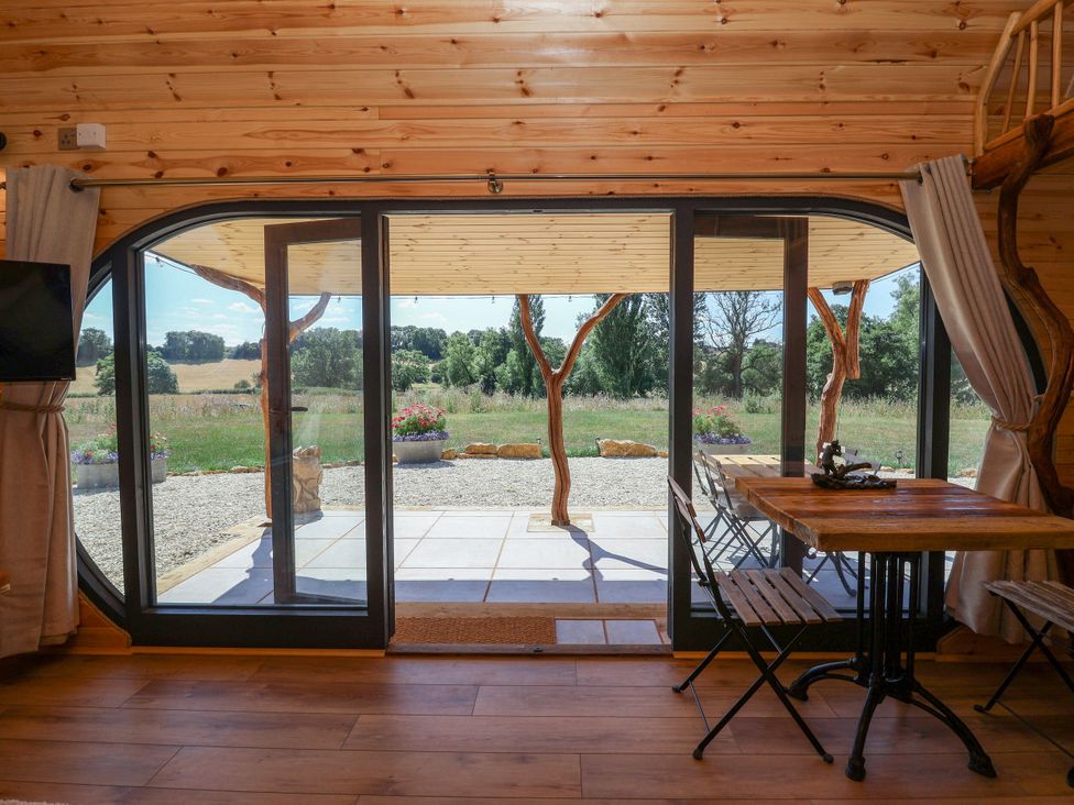 A room with sliding doors and a table at Bugley Pools Hideaway Bugley near Gillingham