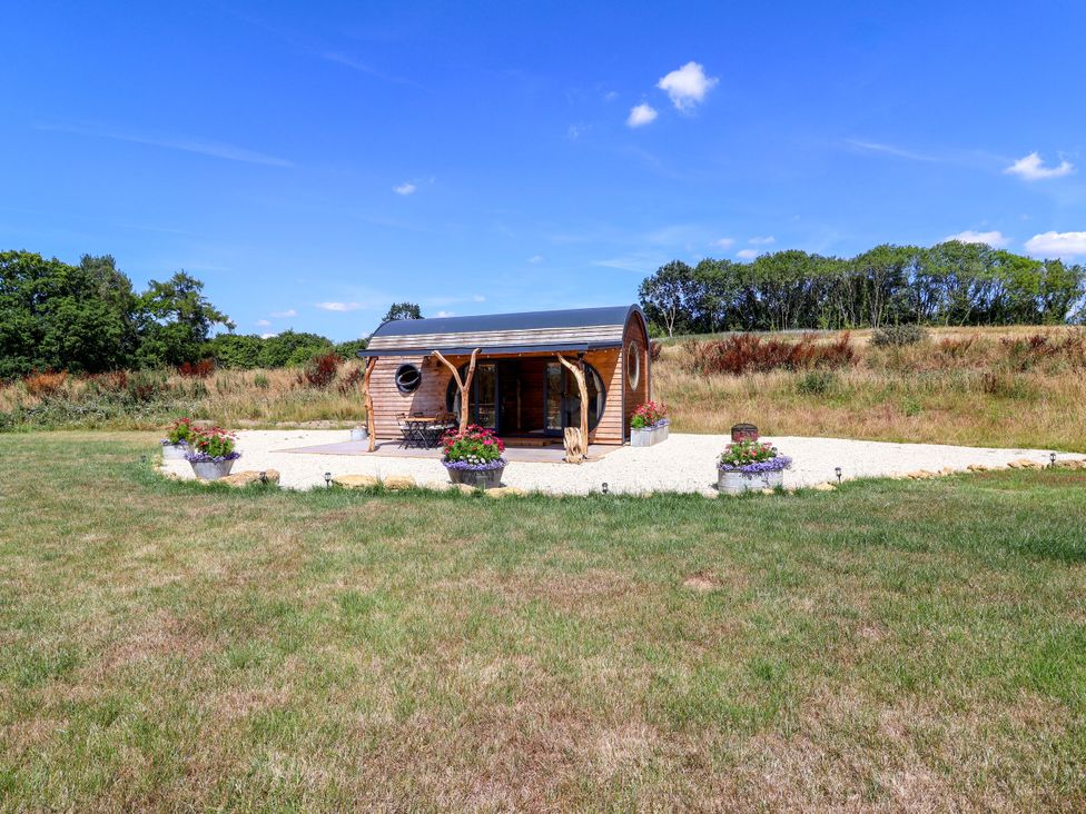 A cabin with flower pots in front at Bugley Pools Hideaway Bugley near Gillingham