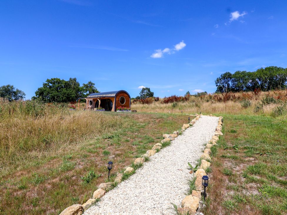 A gravel path leading to a pod-style structure at Bugley Pools Hideaway in Bugley near Gillingham