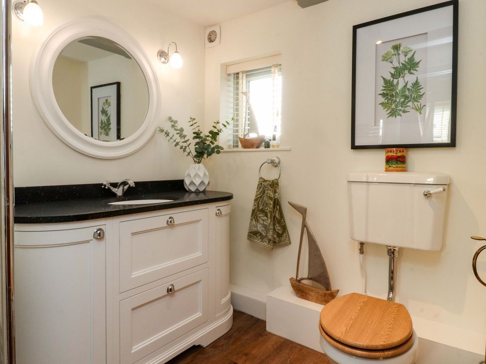 A bathroom with a sink, toilet, and mirror at Cottage in 