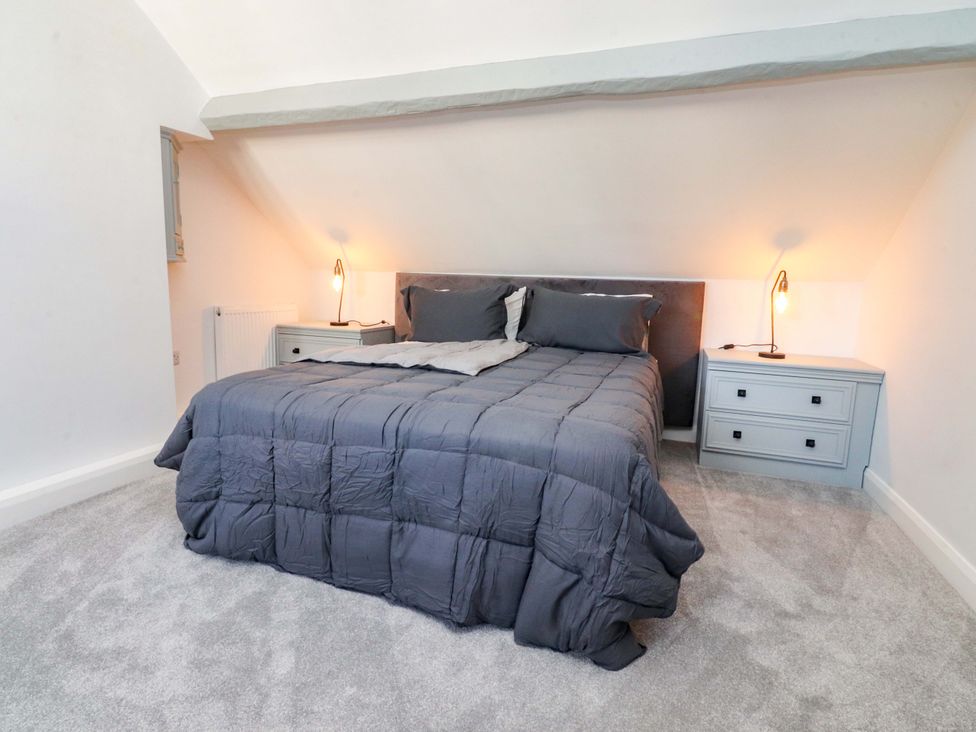 A bedroom with a bed and nightstands at Cottage in 