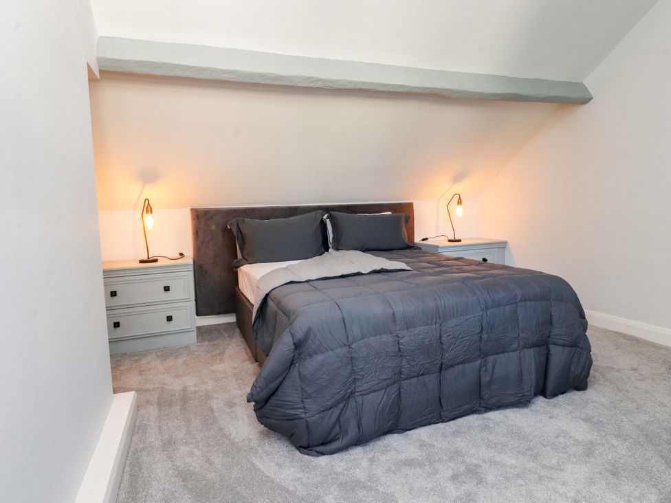 A bedroom with a bed and nightstands at Cottage 