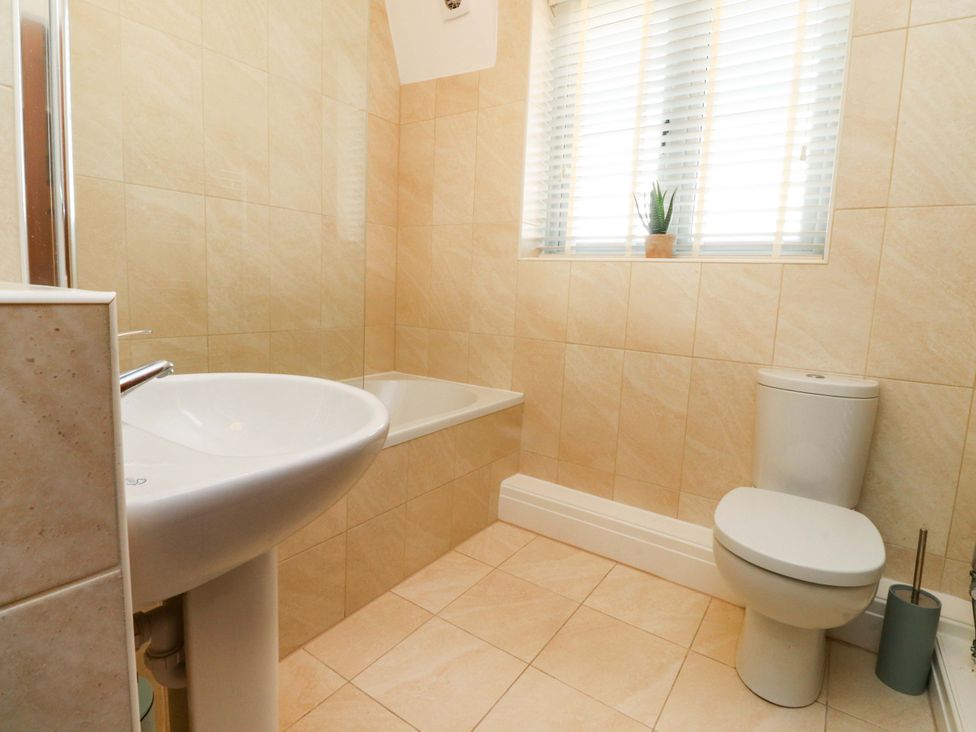 A bathroom with bathtub, wash basin, and toilet at Cottage
