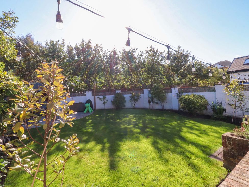 A garden with grass and hanging lights at Cottage