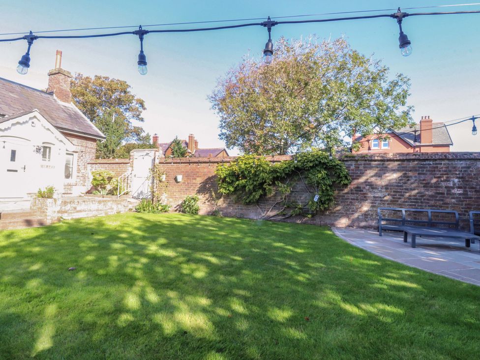 A garden with grass, a tree, and a building at Cottage in 