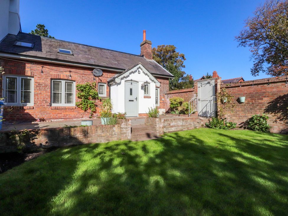 A garden with a brick house and door at Cottage in 