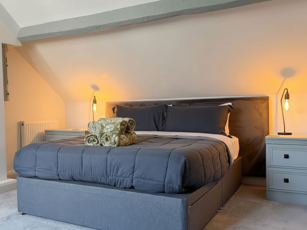A bedroom with a bed and nightstand at Gardener's Cottage in Lytham St. Annes