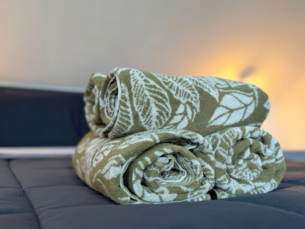 A stack of towels on a bed at Gardener's Cottage in Lytham St. Annes