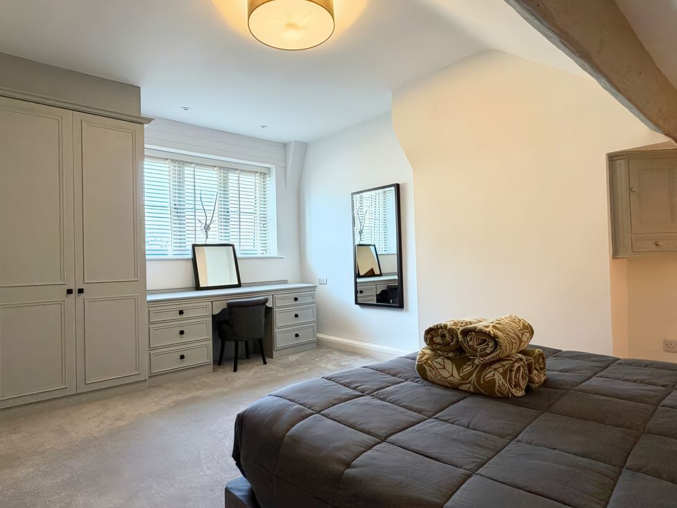 A bedroom with a bed and a workspace at Gardener's Cottage in Lytham St. Annes