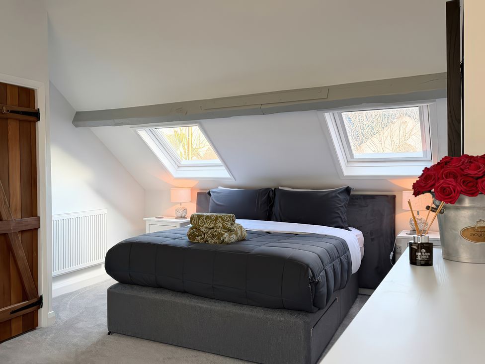 A bedroom with a bed and skylights at Gardener's Cottage in Lytham St. Annes