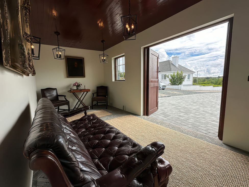 An indoor space with a sofa, table, and chairs at The Garden Cottage and Carriage House, Annagry, County Donegal