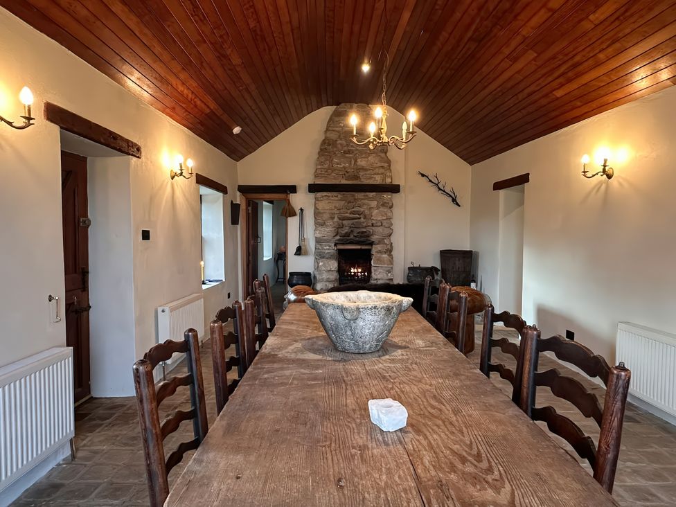 A dining room with a wooden table and chairs at Cobble Stone Cottage near Leabgarrow, County Donegal
