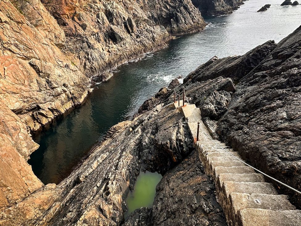 A rocky coastline with a staircase leading down to the water at Cobble Stone Cottage near Leabgarrow, County Donegal