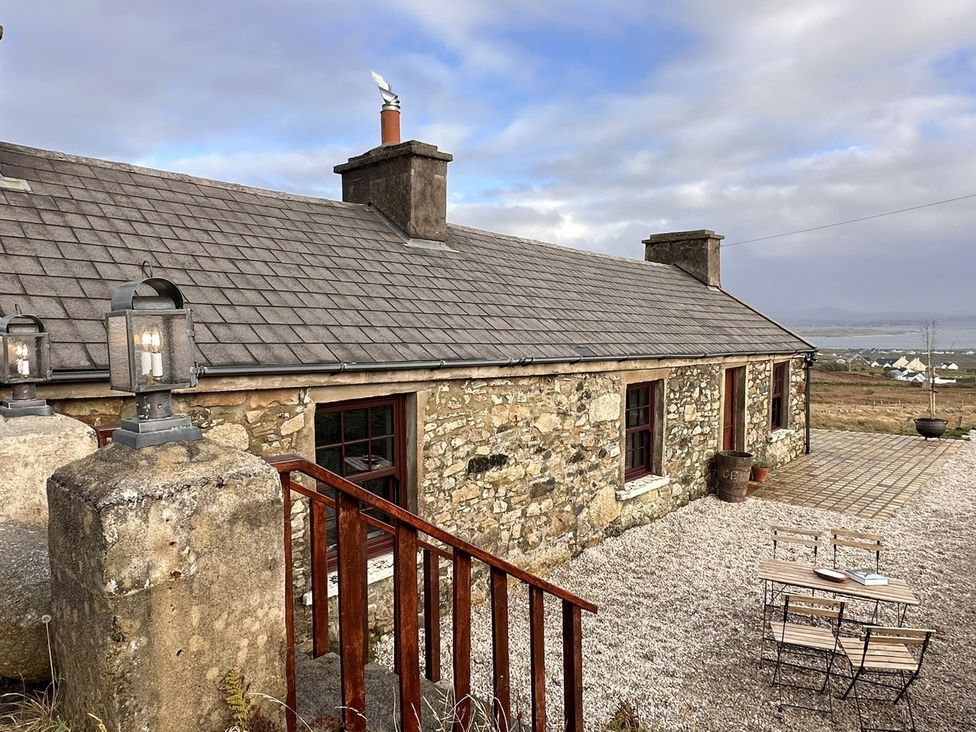 A cottage with stone walls and outdoor seating at Cobble Stone Cottage near Leabgarrow, County Donegal