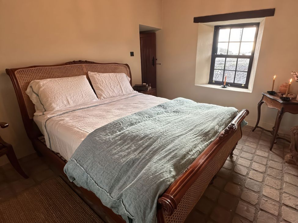 A bedroom with a bed and window at Cobble Stone Cottage near Leabgarrow, County Donegal