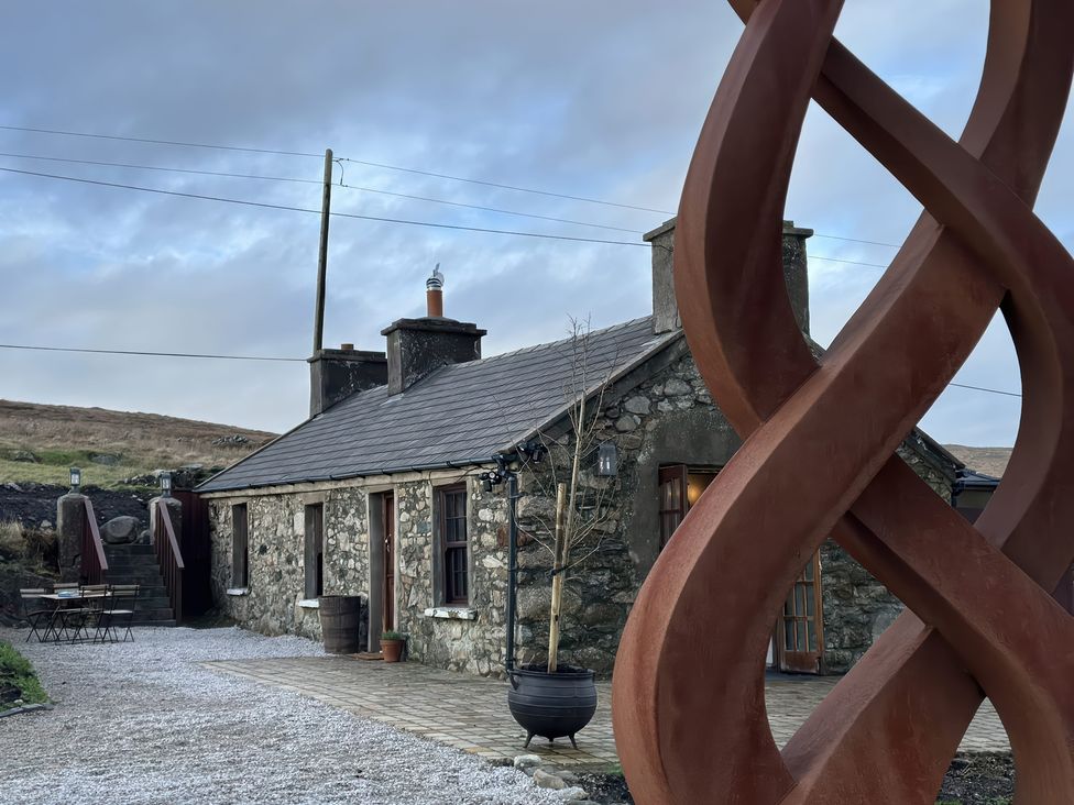 A house with a sculpture in the garden at Cobble Stone Cottage near Leabgarrow, County Donegal