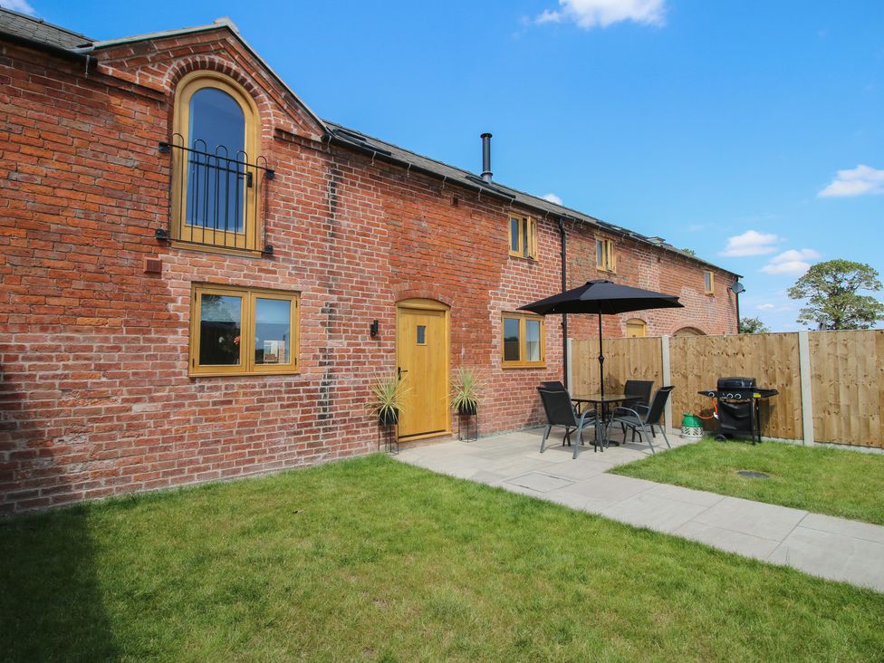 An outdoor area with a table, chairs, and barbecue at Ash Barn in Shrewsbury