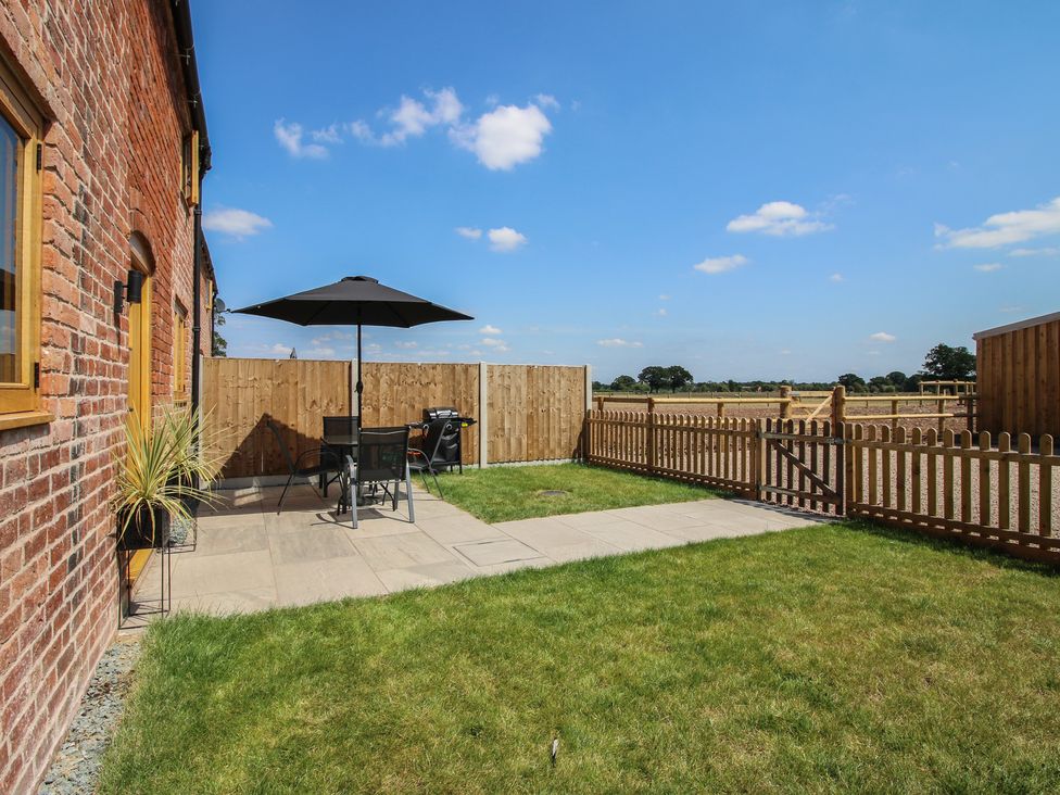 A garden with a patio area and furniture at Ash Barn in Shrewsbury