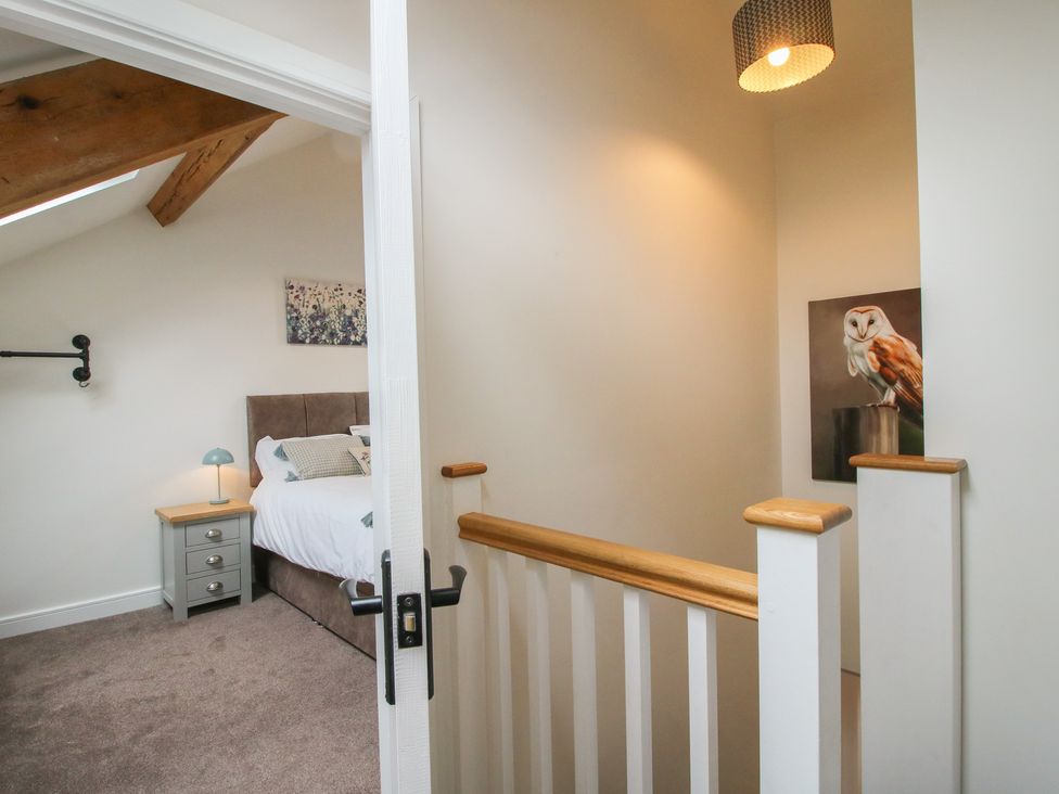 A landing area with a bed and painting at Ash Barn Northwood near Wem