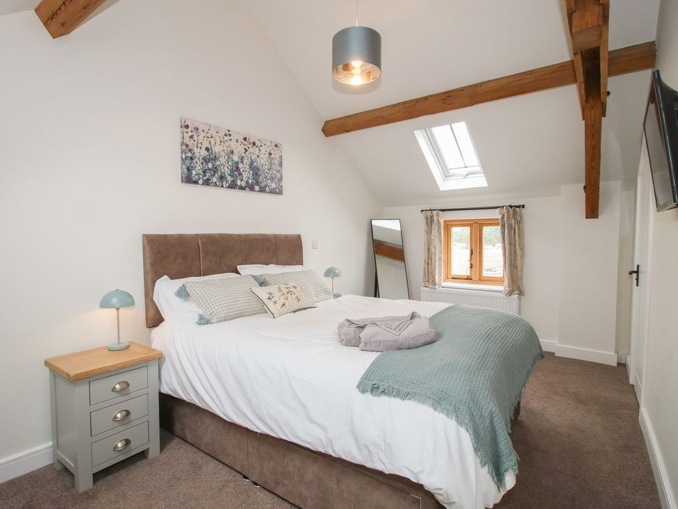 A bedroom with a bed and bedside table at Ash Barn near Wem