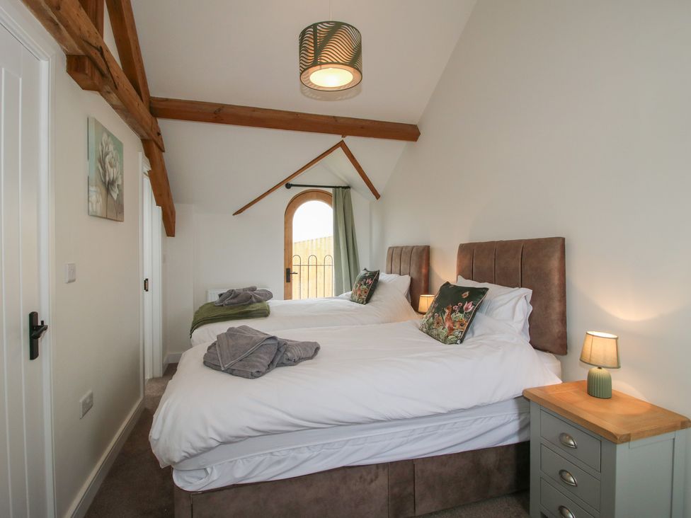 A bedroom with two beds and a window at Ash Barn Northwood near Wem