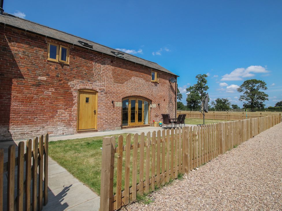 An outdoor area with brick exterior and patio furniture at Willow Barn in Shrewsbury