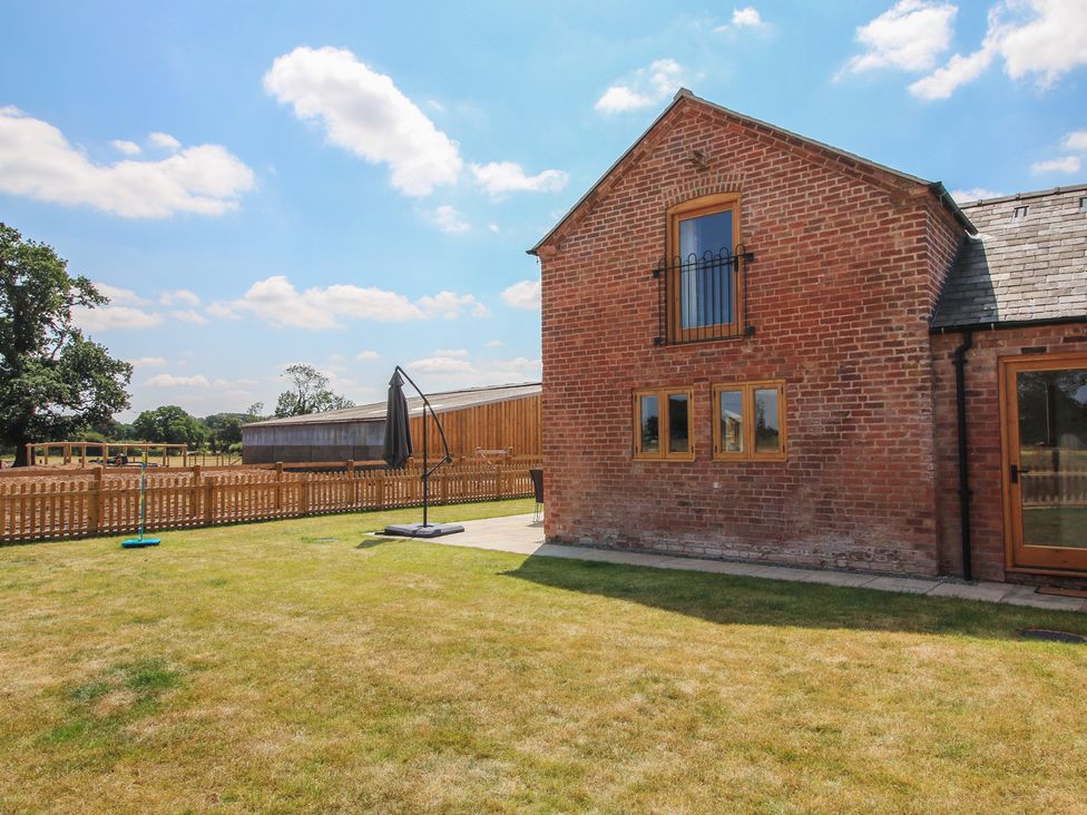 A house with windows and a fence in the yard at Willow Barn in Shrewsbury