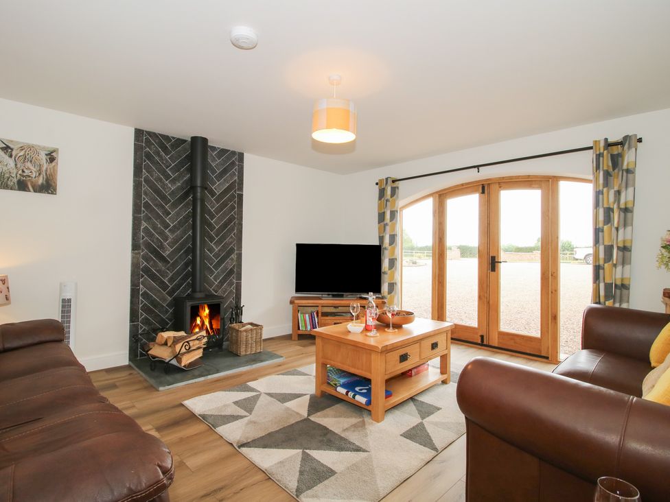 A living room with a fireplace and couch at Willow Barn in Northwood near Wem