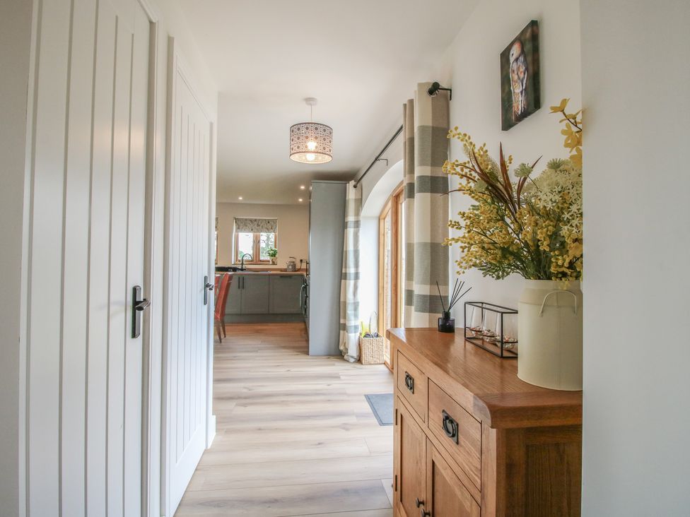 A hallway with a wooden console table and light fixture at Willow Barn Northwood near Wem