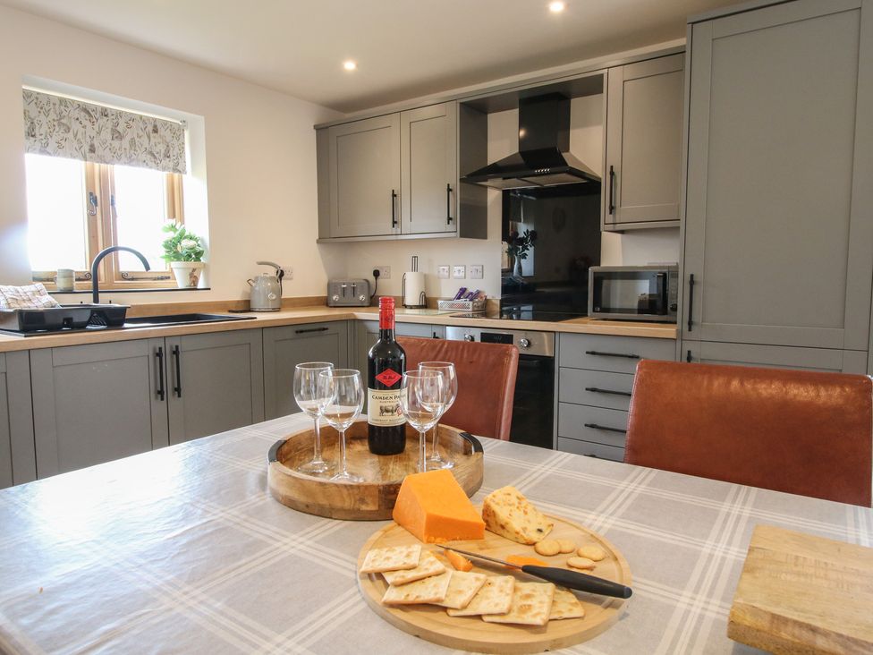 A kitchen with a table set for cheese and wine at Willow Barn in Northwood near Wem