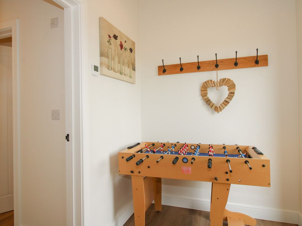 A game room with a foosball table and wall hooks at Willow Barn Northwood near Wem