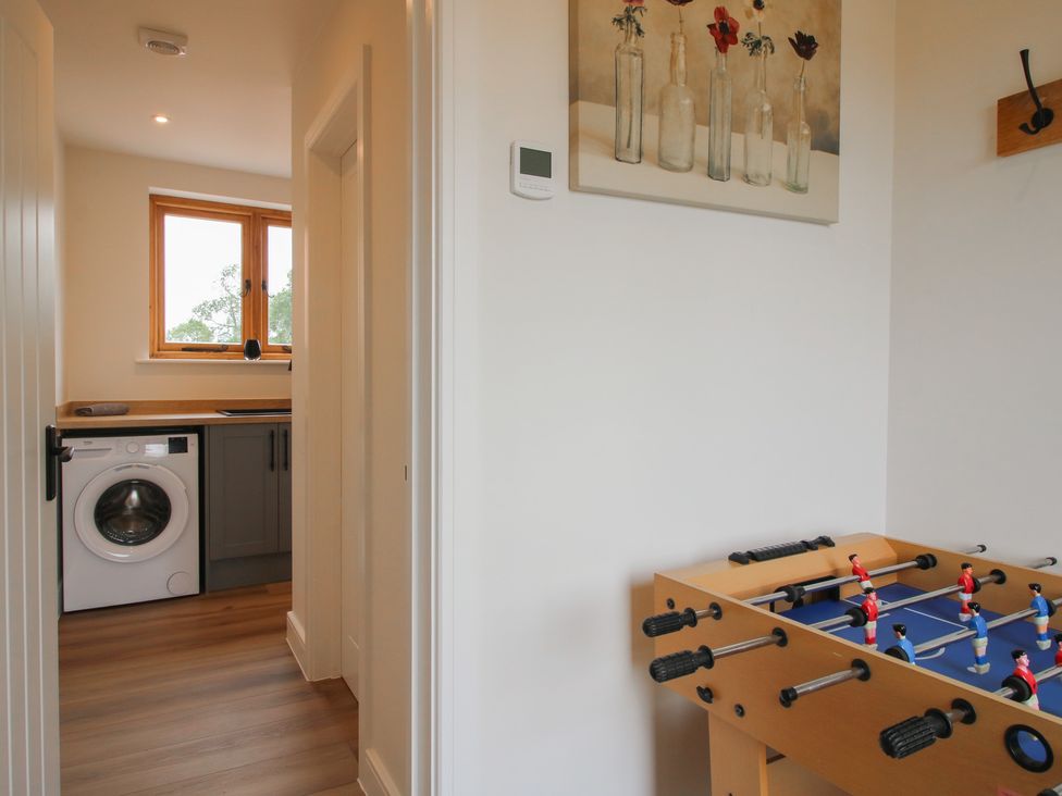 A utility room with a washing machine and a foosball table at Willow Barn in Northwood near Wem