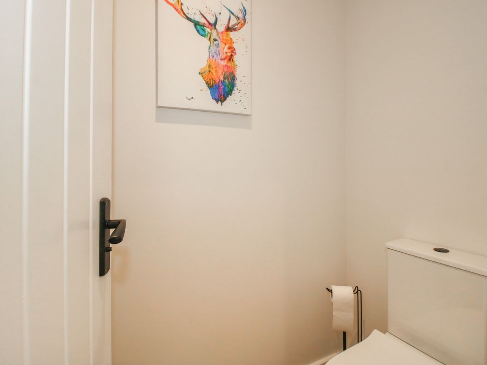 A bathroom with a toilet and artwork at Willow Barn Northwood near Wem