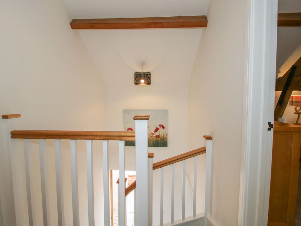 A stairway with a handrail and wall art at Willow Barn Northwood near Wem