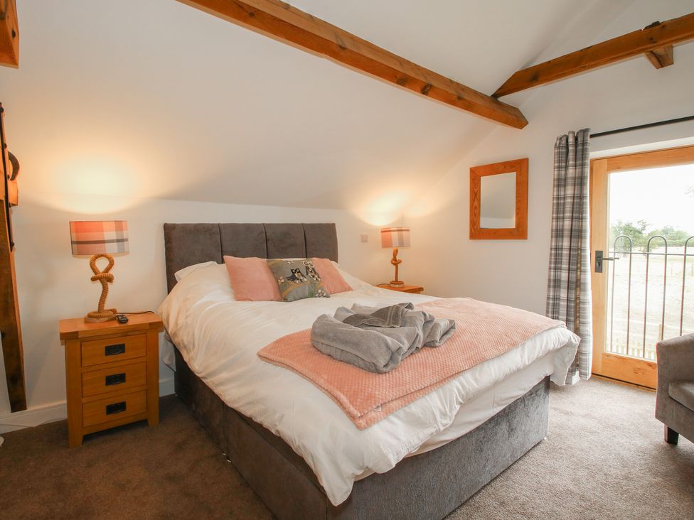 A bedroom with a bed and nightstand at Willow Barn Northwood near Wem