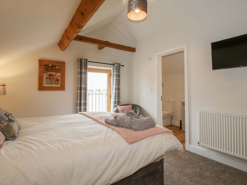 A bedroom with a bed and a television at Willow Barn in Northwood near Wem
