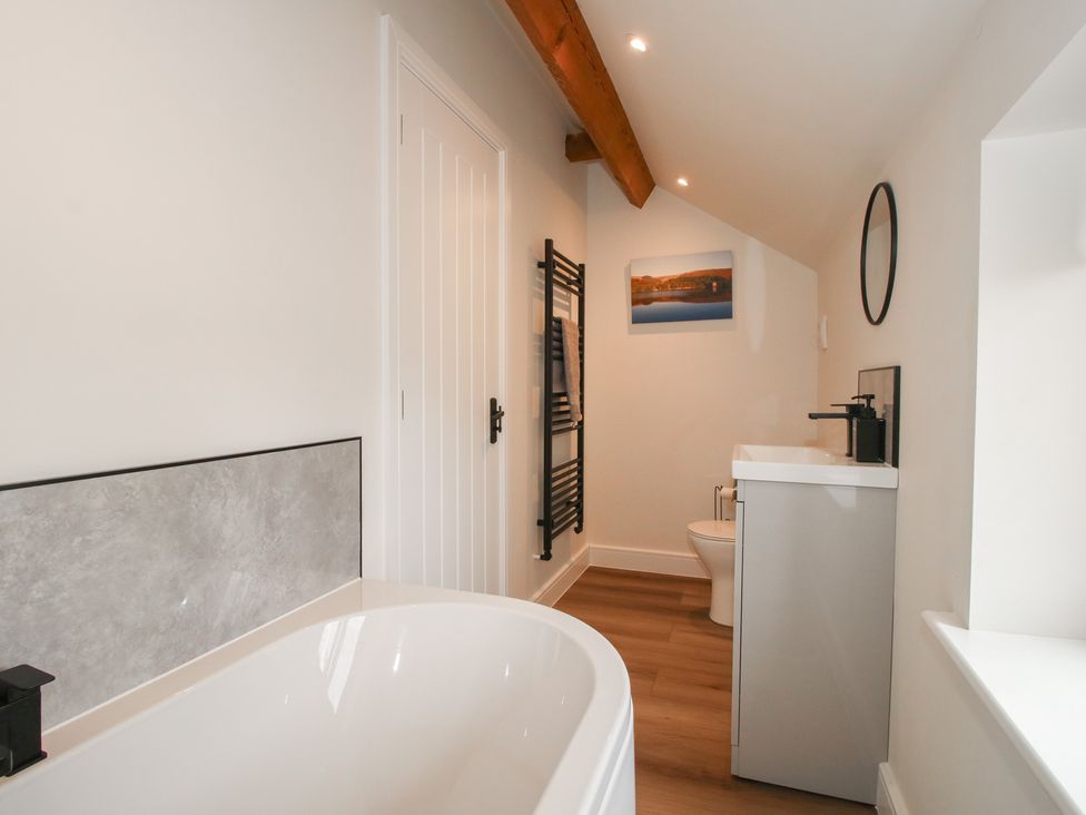 A bathroom with a bathtub, toilet, and vanity unit at Willow Barn Northwood near Wem