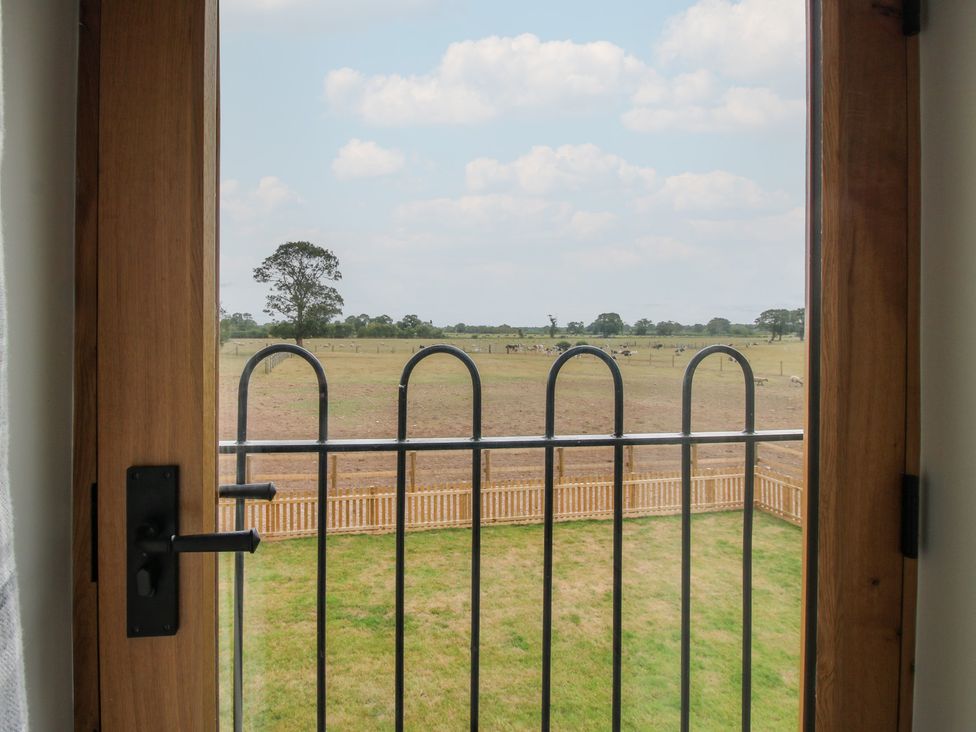 A view from a window showing grass and trees at Willow Barn Northwood near Wem