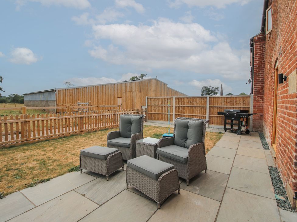 A garden with patio furniture and a grill at Willow Barn in Northwood near Wem