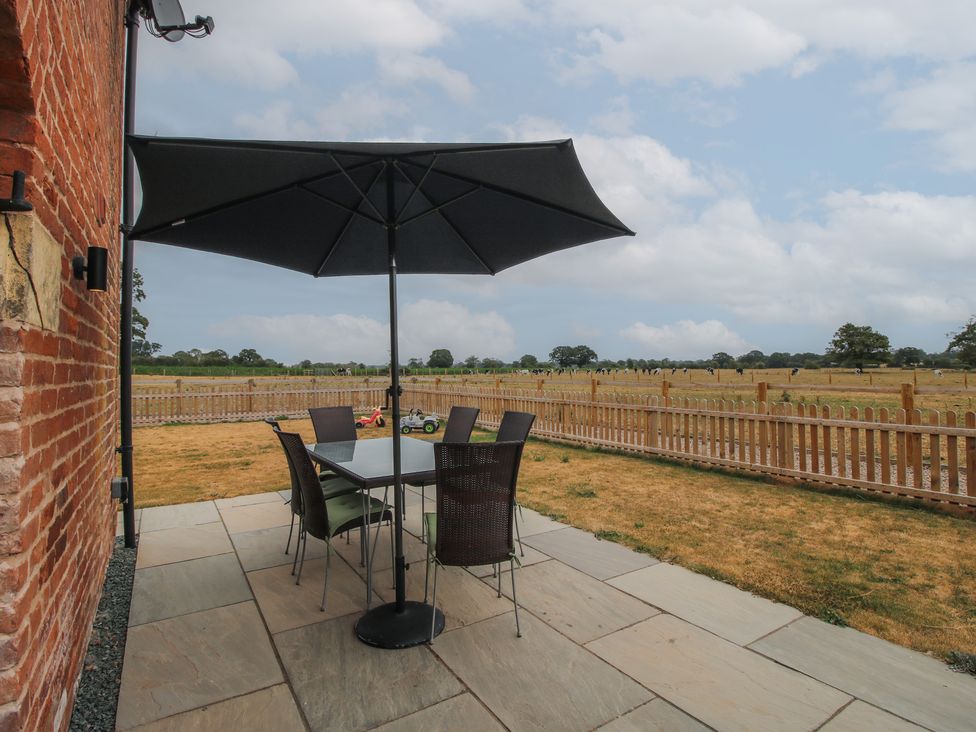 An outdoor dining area with a table and chairs at Willow Barn Northwood near Wem