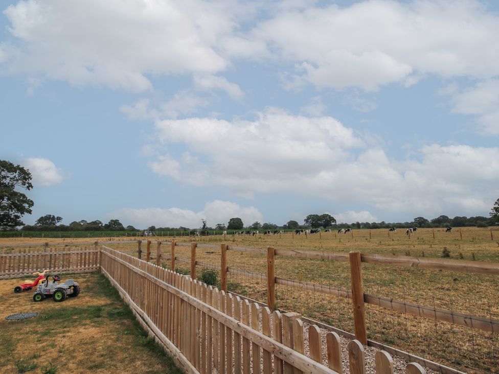 An outdoor area with a fence and toy cars at Willow Barn Northwood near Wem