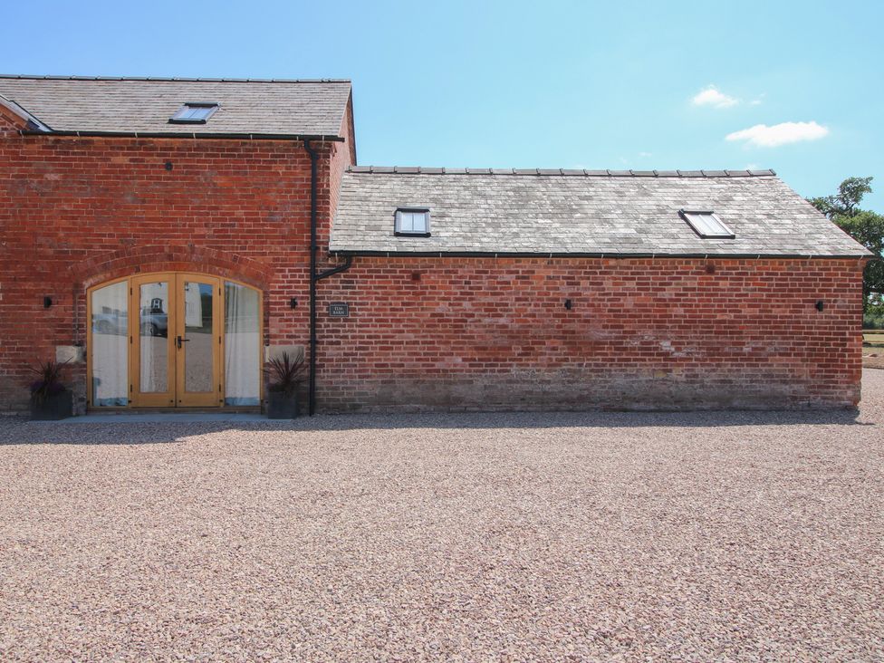 An exterior view of a brick building with double doors at Elm Barn in Shrewsbury