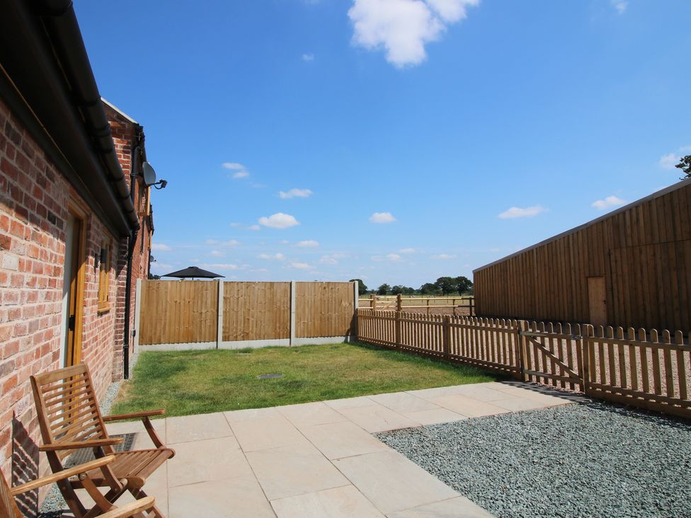 A garden with grass and seating area at Elm Barn in Shrewsbury