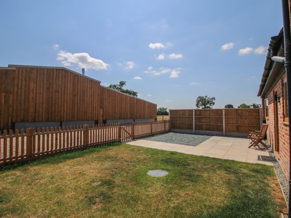 A garden with grass, patio, and gravel at Elm Barn in Shrewsbury