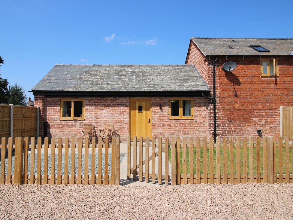 A brick house with a wooden door and windows at Elm Barn in Shrewsbury