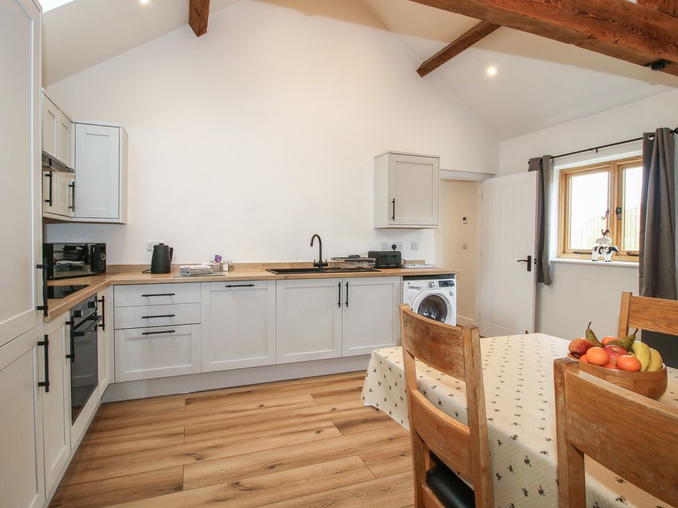 A kitchen with wooden furniture and appliances at Elm Barn Northwood near Wem