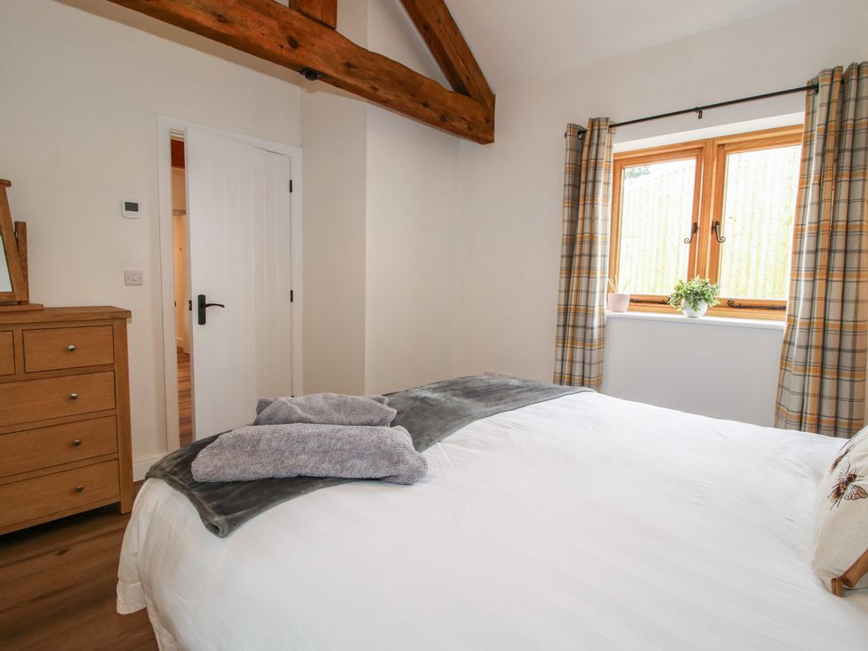 A bedroom with a bed and a dressing table at Elm Barn Northwood near Wem