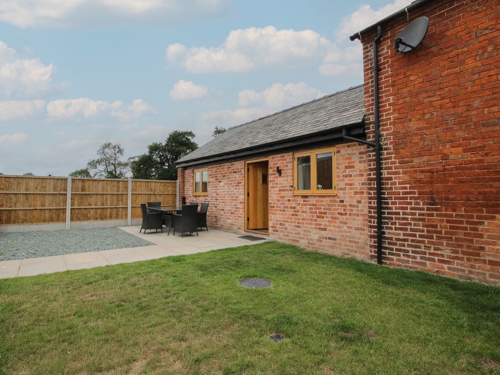 An outdoor seating area with table and chairs at Elm Barn Northwood near Wem