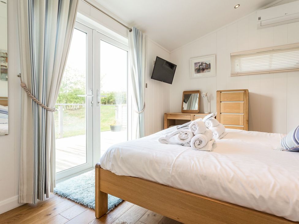 A bedroom with a bed and dresser at 2 Tree Tops in Lanreath