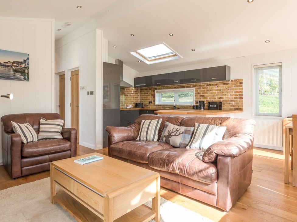 A living room with a sofa and coffee table at 2 Tree Tops in Lanreath